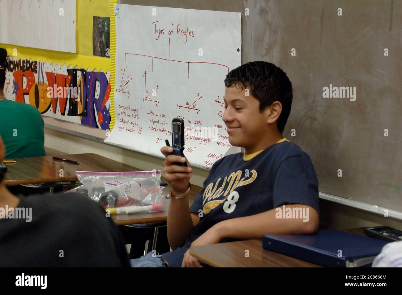 Brownsville, Texas États-Unis, 2 décembre 2005 : un étudiant de sexe masculin utilise son téléphone portable pour prendre une photo dans sa salle de classe au lycée Lopez, où la population étudiante de Lopez HS est à plus de 99% hispanique. ©Bob Daemmrich Banque D'Images