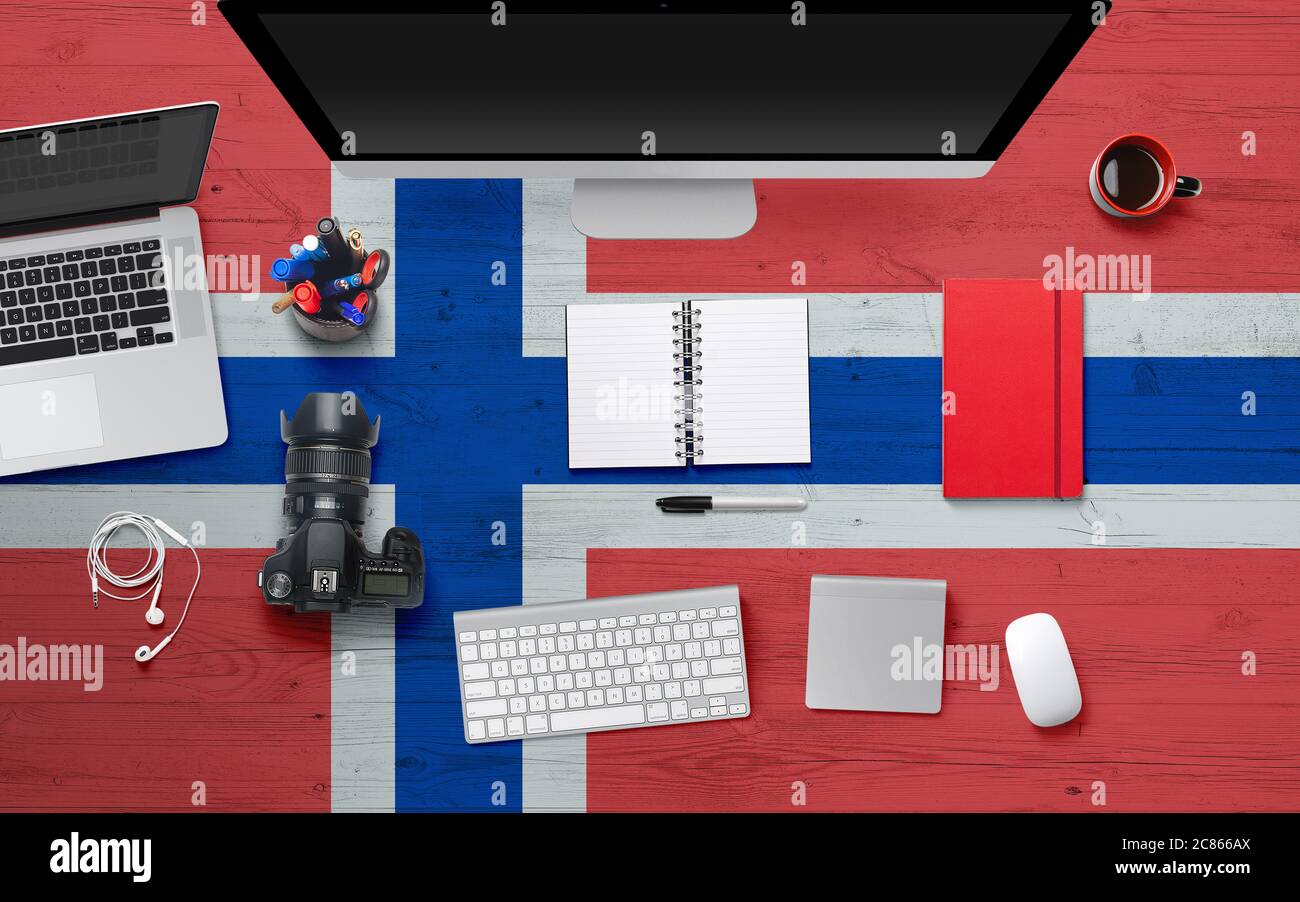 Arrière-plan drapeau norvégien avec casque, appareil photo, ordinateur portable et souris sur la table de bureau nationale.vue du dessus avec espace pour copier.pose à plat. Banque D'Images