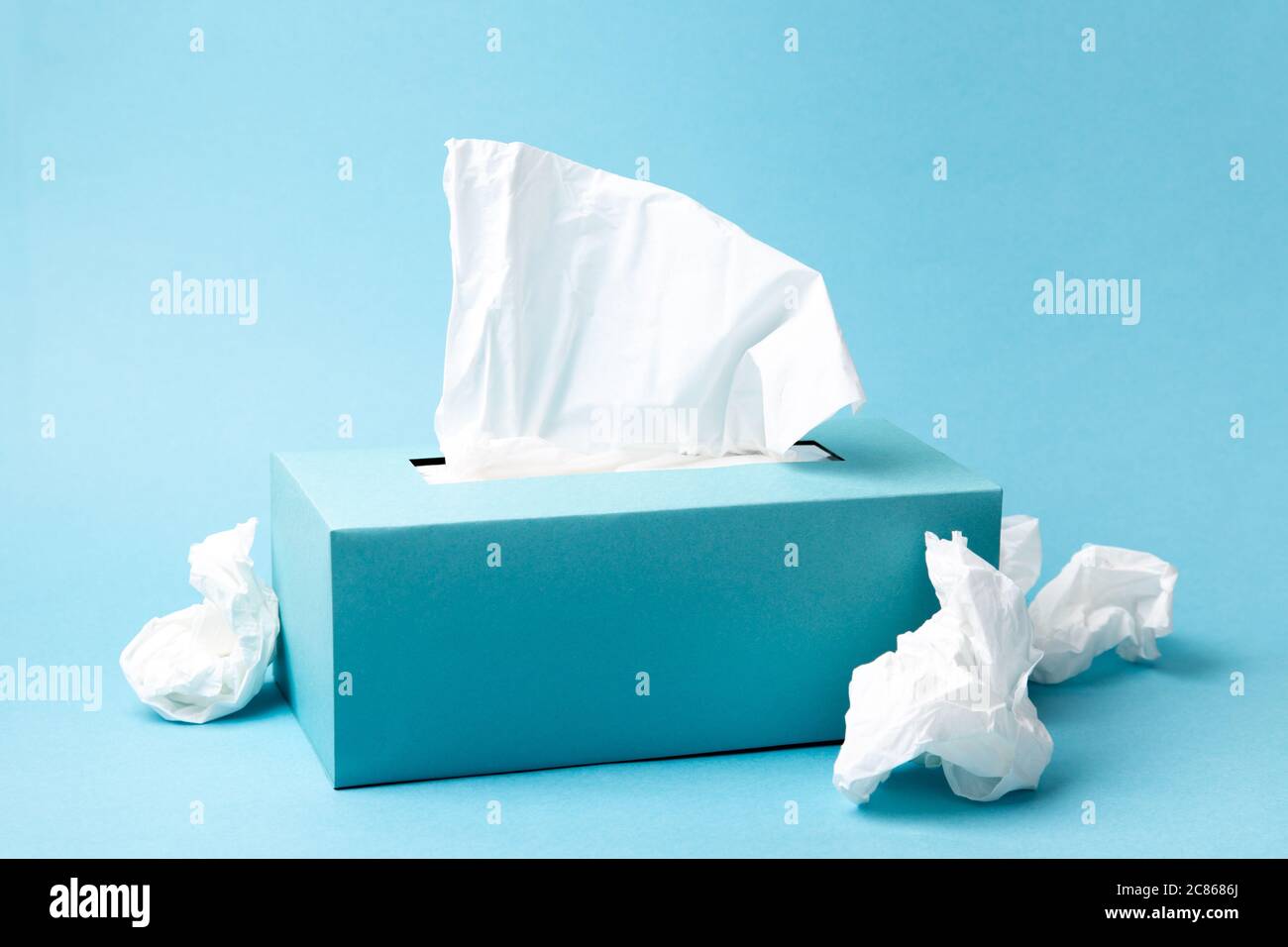 Boîte de mouchoirs bleu clair et mouchoirs froissés sur fond bleu. Le froid  et la grippe concept. Composition monochromatique minimale Photo Stock -  Alamy