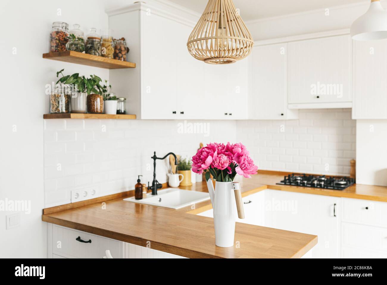 Fleurs pivoines dans vase sur cuisine blanche propre dans le style moderne, détails de cuisine. Séjour durable cuisine écologique Banque D'Images