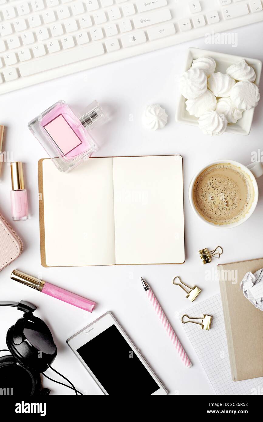 espace de travail avec clavier pour ordinateur portable, carnet d'esquisses, agenda, café et accessoires féminins sur fond blanc. Bureau avec table et vue sur le dessus. Banque D'Images