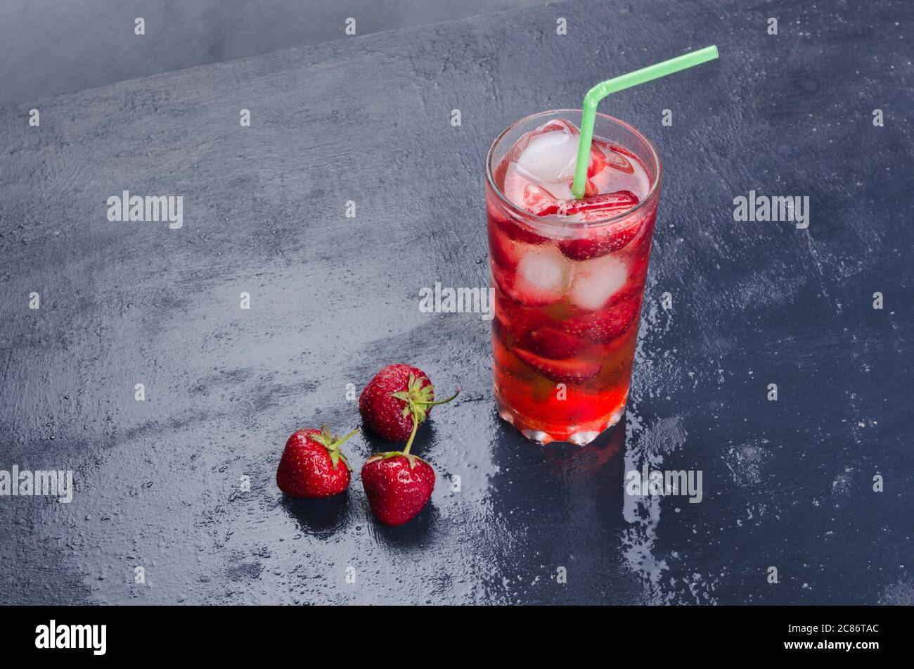 Cocktail d'alcool aux fraises sur table sombre Banque D'Images