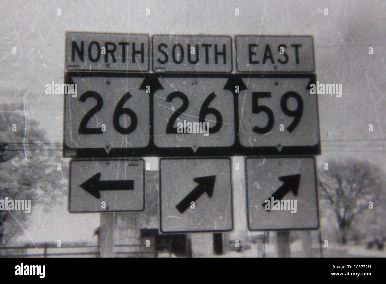 Fin années 70 vintage noir et blanc style de vie photographie de panneaux de route de diverses directions. Banque D'Images