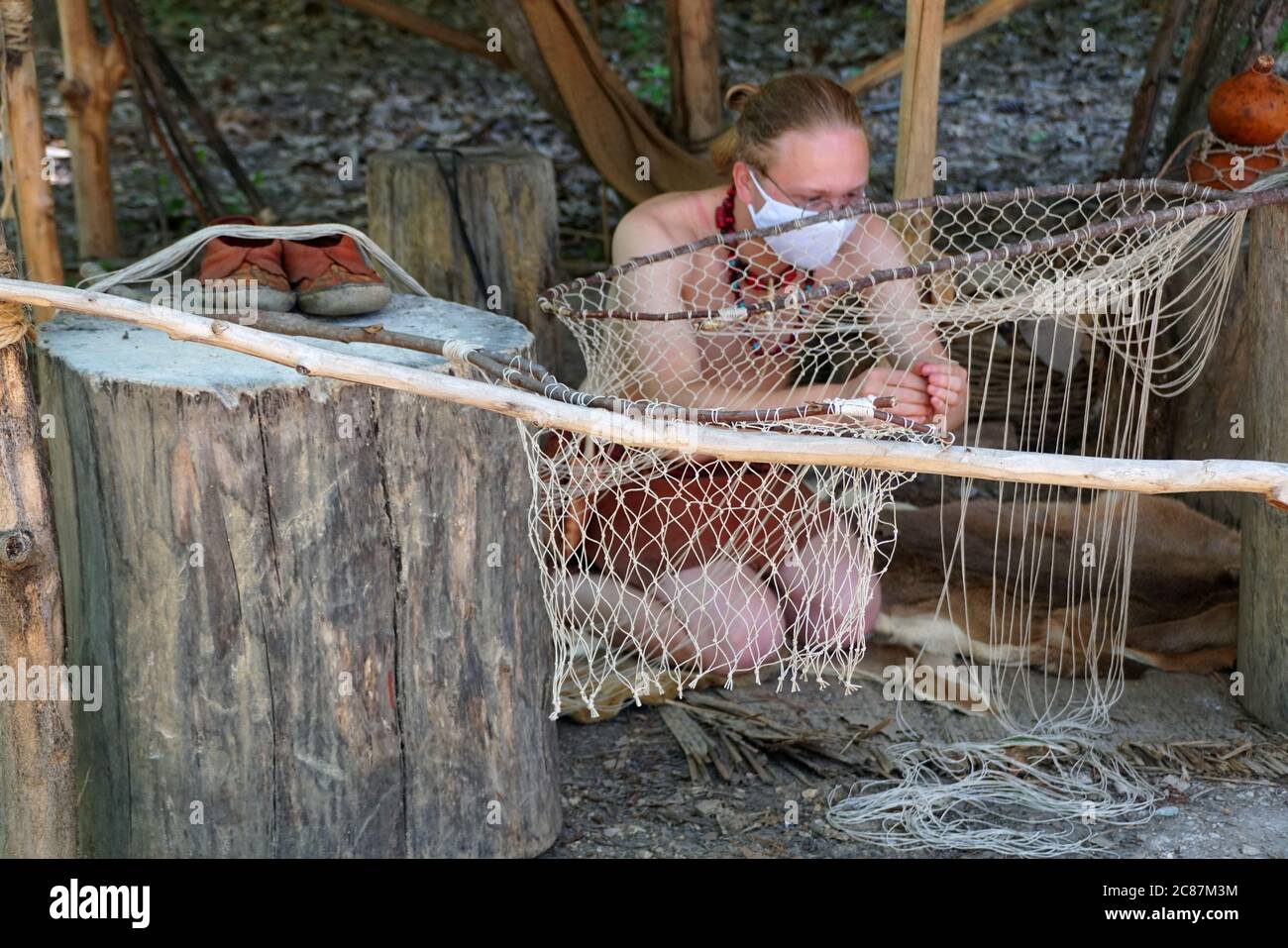 Virginia, États-Unis - 1er juillet 2020 - UN homme qui coudre et tricoter le filet de pêche tout en portant un masque Banque D'Images