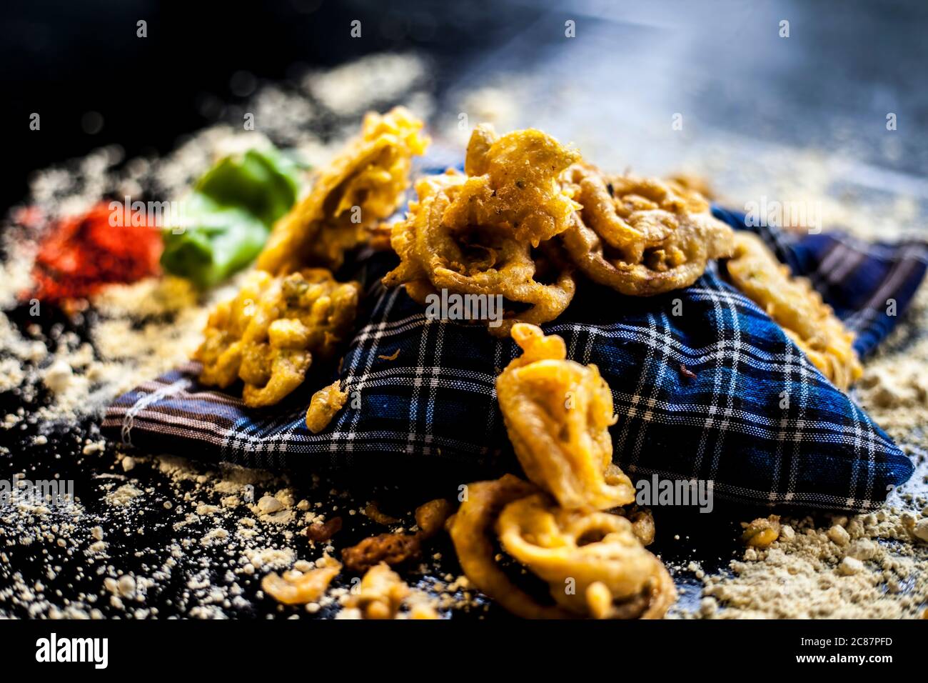 Célèbre kanda bhaji ou kanda bhajiya ou kanda pakora dans un récipient sur une surface noire avec la farine de pois chiches, les épices, et tous les autres ingrédients pour Banque D'Images