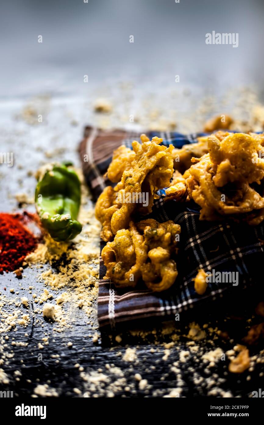 Célèbre kanda bhaji ou kanda bhajiya ou kanda pakora dans un récipient sur une surface noire avec la farine de pois chiches, les épices, et tous les autres ingrédients pour Banque D'Images
