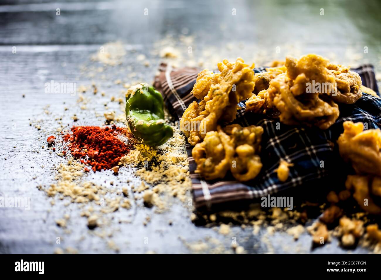 Célèbre kanda bhaji ou kanda bhajiya ou kanda pakora dans un récipient sur une surface noire avec la farine de pois chiches, les épices, et tous les autres ingrédients pour Banque D'Images