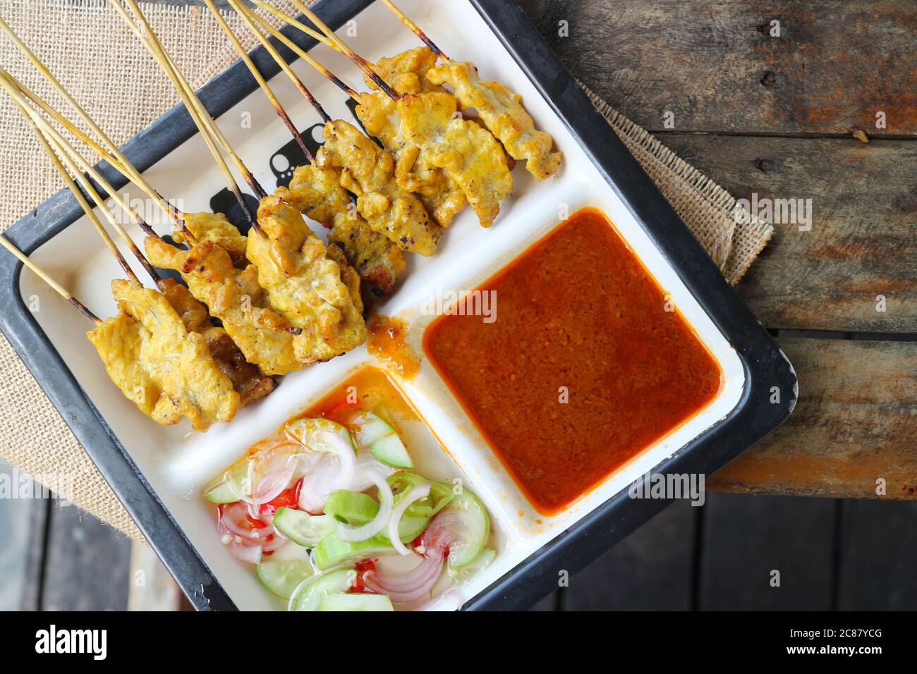 Satay de porc - porc grillé mariné au curry servi avec une sauce à l'arachide et une sauce aux légumes aigre et douce Banque D'Images
