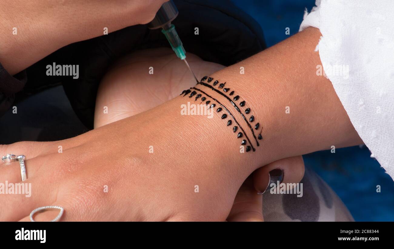 Artiste appliquant le tatouage au henné sur la main de femme. Le mehndi est un art décoratif indien traditionnel Banque D'Images