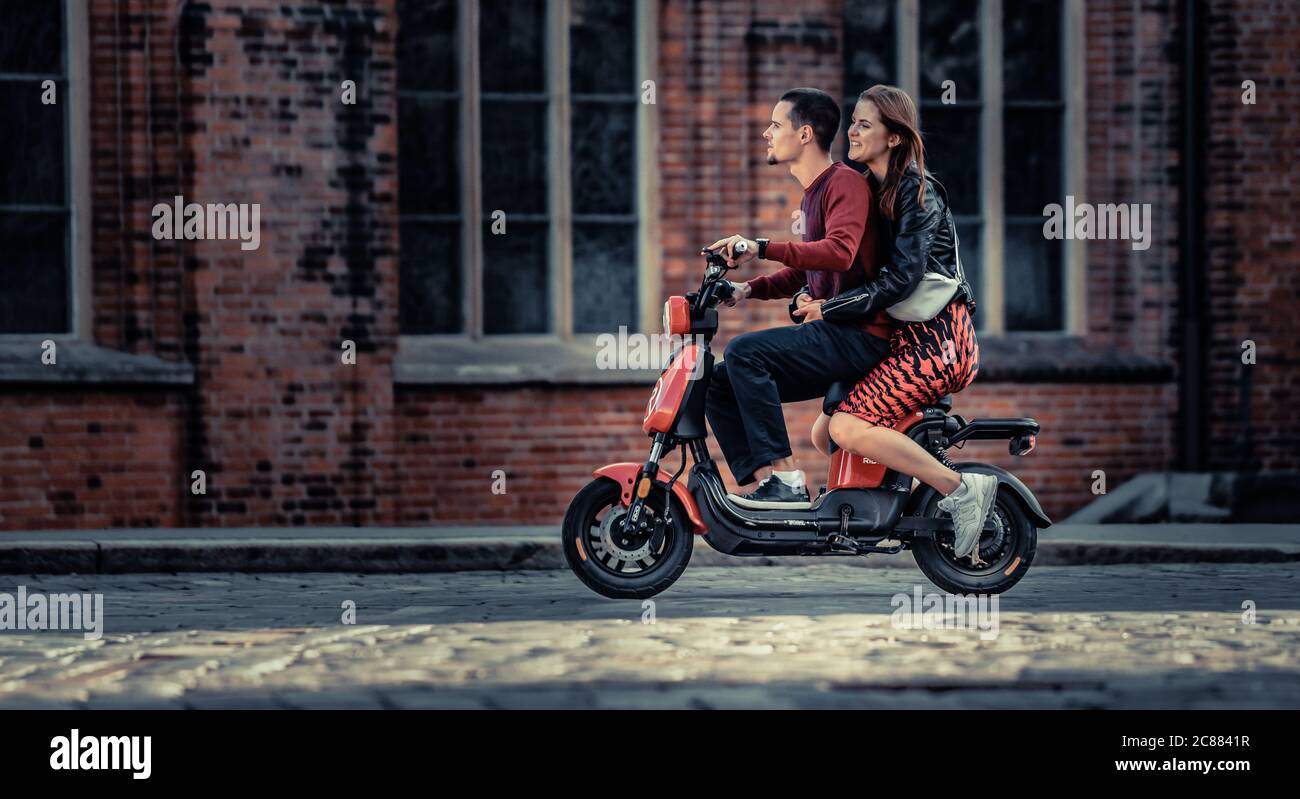 20-07-2020 Riga, Lettonie charmant jeune couple conduisant du vélo électrique pendant l'été. Ville moderne datant et transport. Banque D'Images