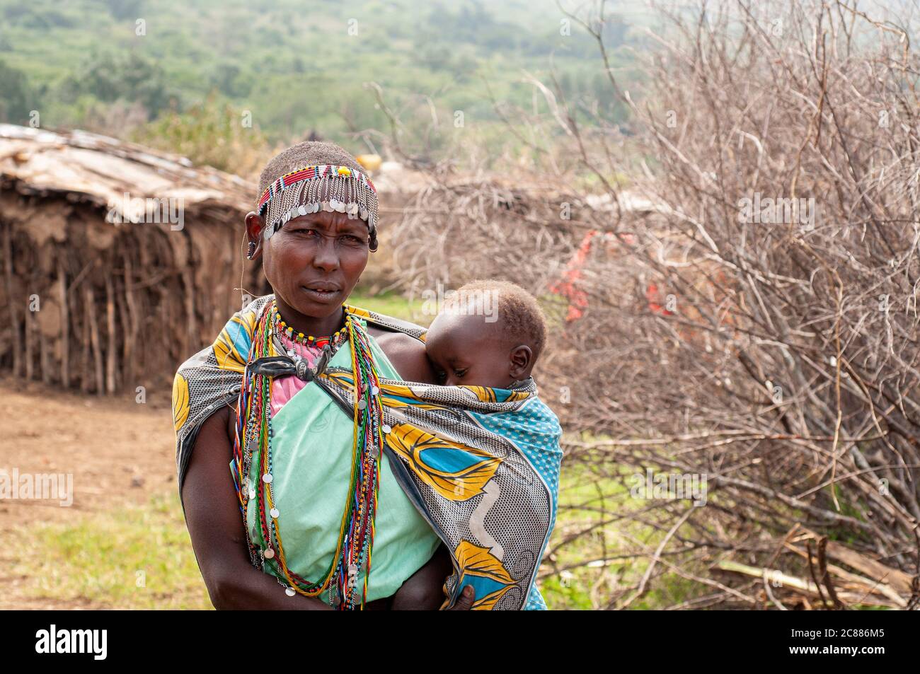 Maasai jeune mère et bébé, portant une tenue traditionnelle, dans un village de maasai. Réserve nationale de Maasai Mara. Kenya. Afrique. Banque D'Images