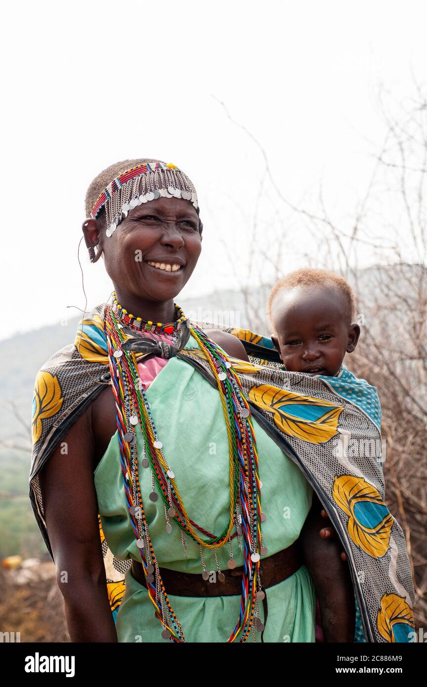 Maasai jeune mère et bébé, portant une tenue traditionnelle, dans un village de maasai. Réserve nationale de Maasai Mara. Kenya. Afrique. Banque D'Images
