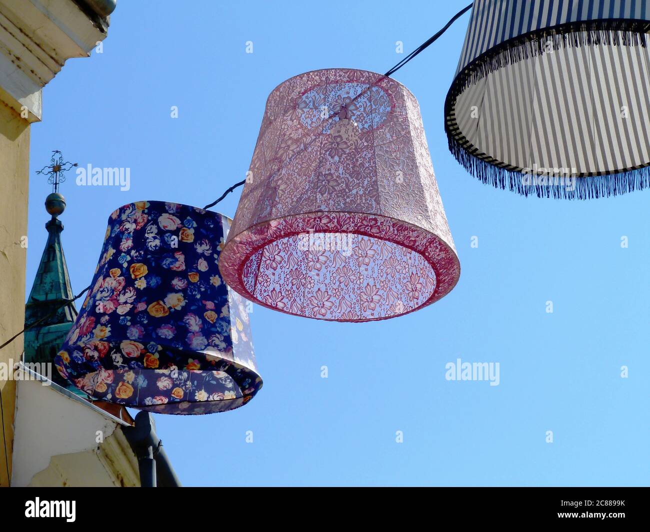 Lumières extérieures en toile colorées, lanternes ou lampes au-dessus de la rue publique dans une ville pittoresque d'Europe. ambiance de fête et de vacances d'été Banque D'Images