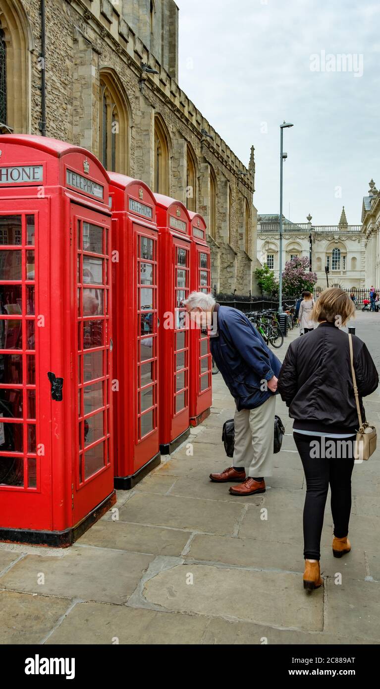 Les téléphones britanniques de style ancien vus alignés par une grande église dans la ville universitaire de Cambridge. Banque D'Images