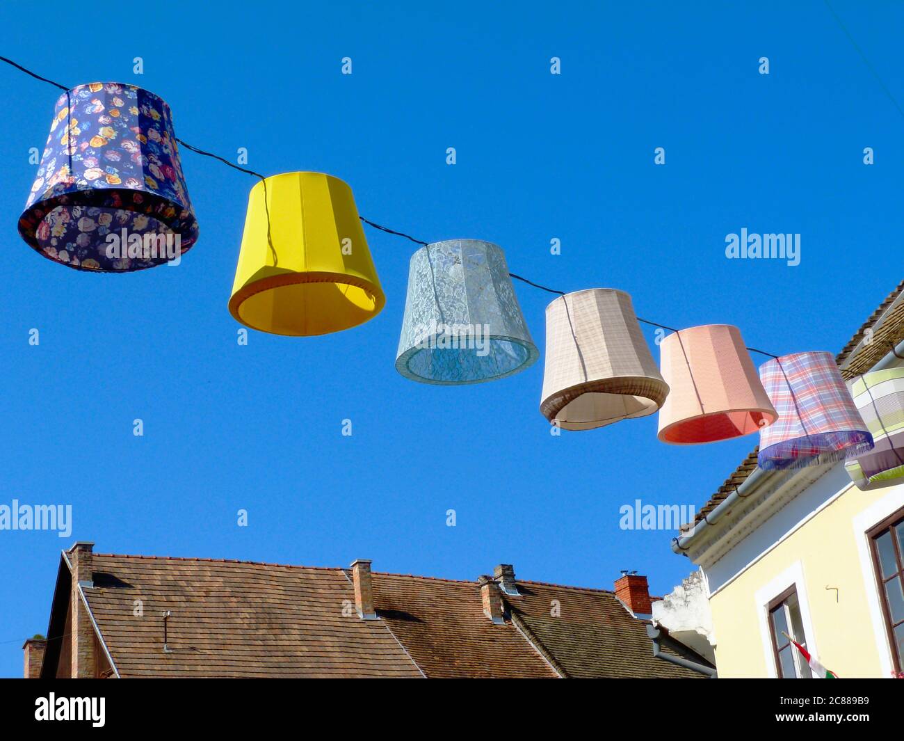 Lumières extérieures en toile colorées, lanternes ou lampes au-dessus de la rue publique dans une ville pittoresque d'Europe. ambiance de fête et de vacances d'été Banque D'Images