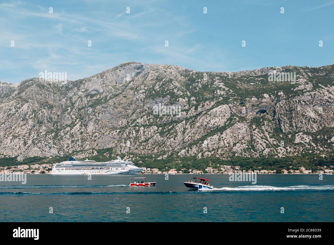 Croisière blanche sur plusieurs étages, sur fond de montagne. Deux bateaux à moteur naviguent l'un sur l'autre. Banque D'Images