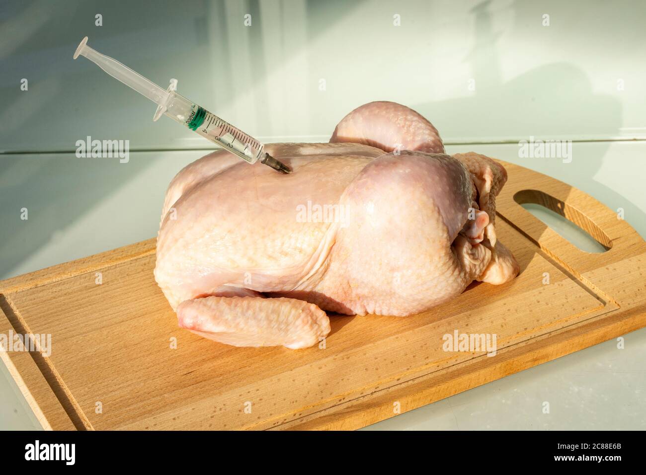 poulet cru et seringue. hormones de croissance et antibiotiques dans la viande de poulet Banque D'Images