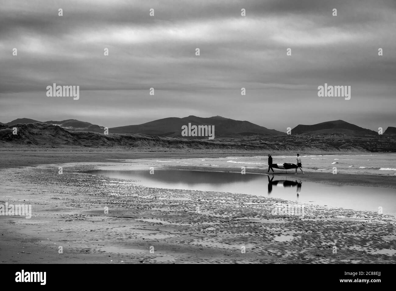 Hommes B&W transportant un bateau, pays de Galles Banque D'Images