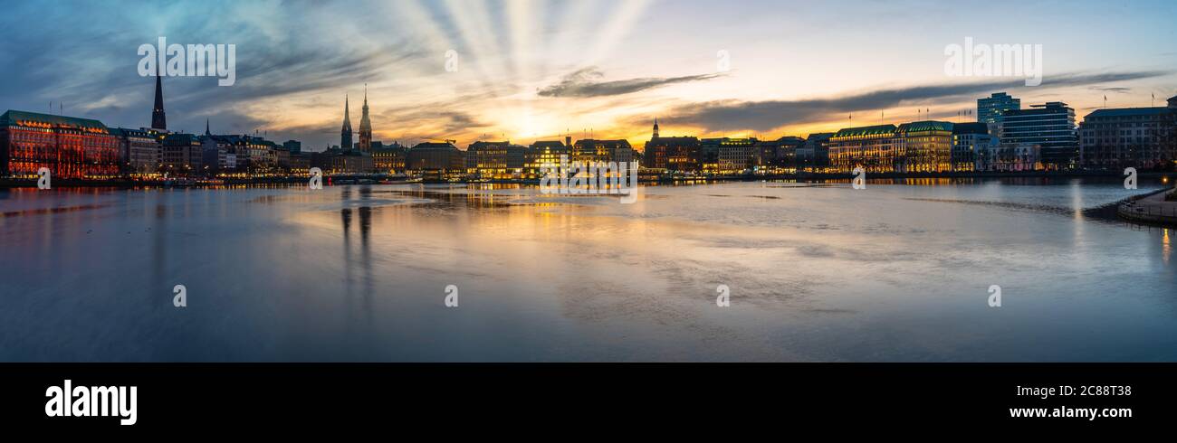 Vue panoramique sur le lac Alster et le paysage urbain à Hambourg, en Allemagne, au coucher du soleil sur un ciel spectaculaire Banque D'Images