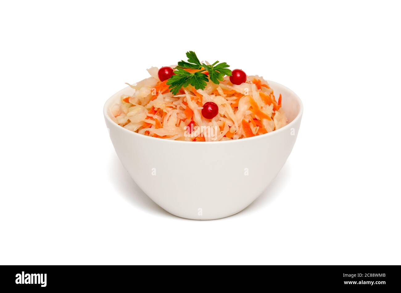 Choucroute avec carotte dans un bol en céramique blanc sur fond blanc. Plats fermentés faits maison. Concept de saine alimentation et alimentation. Gros plan. Copier l'espace Banque D'Images