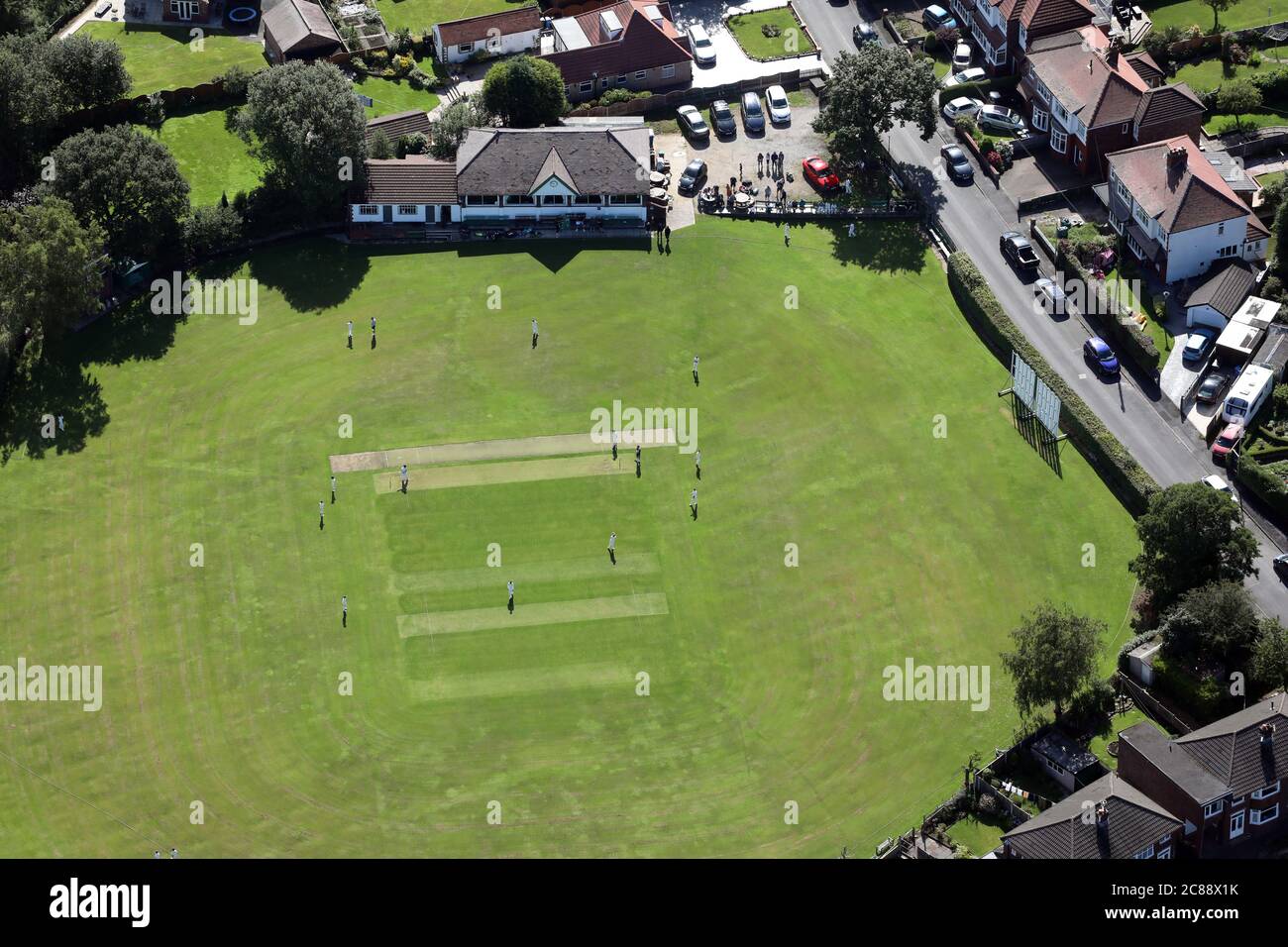 Vue aérienne d'un match de cricket du village qui a lieu un dimanche matin Banque D'Images