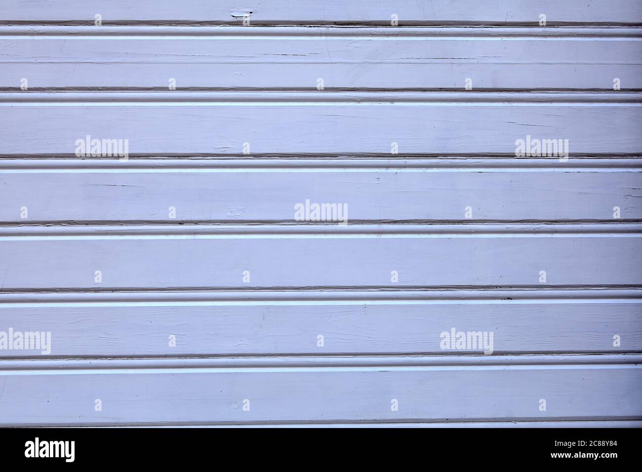 Texture à faible contraste d'un mur en bois, teinte blanc-bleu. Un bâtiment recouvert de bois bleu pâle, texture abstraite pour le fond. Banque D'Images