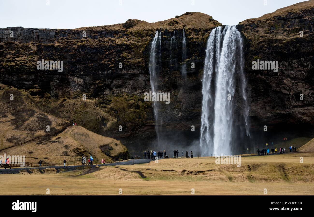 Touristes appréciant la cascade et la rivière Skogafoss en Islande Banque D'Images