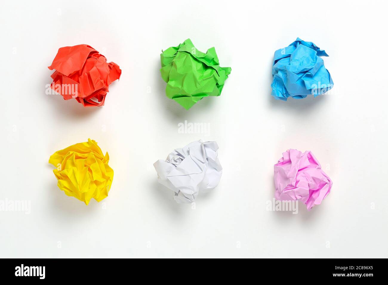 six boules de papier froissé colorées sur une surface blanche Banque D'Images