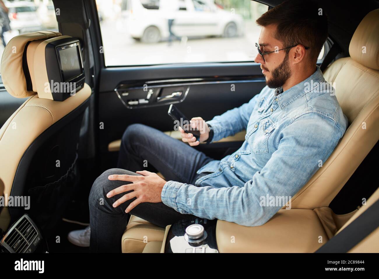 un homme charmant va passer un appel téléphonique. photo vue latérale. Internet. Man regarde le téléphone. Guy téléchargement de musique, d'images. De films Banque D'Images