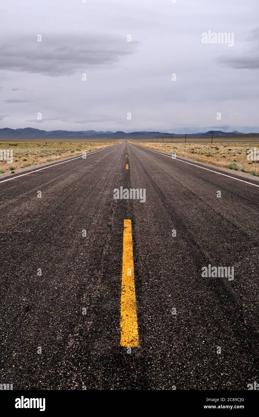 Photo verticale regardant en bas d'une étendue solitaire de l'autoroute 6 sous le ciel couvert dans le comté de Nye, Nevada Banque D'Images