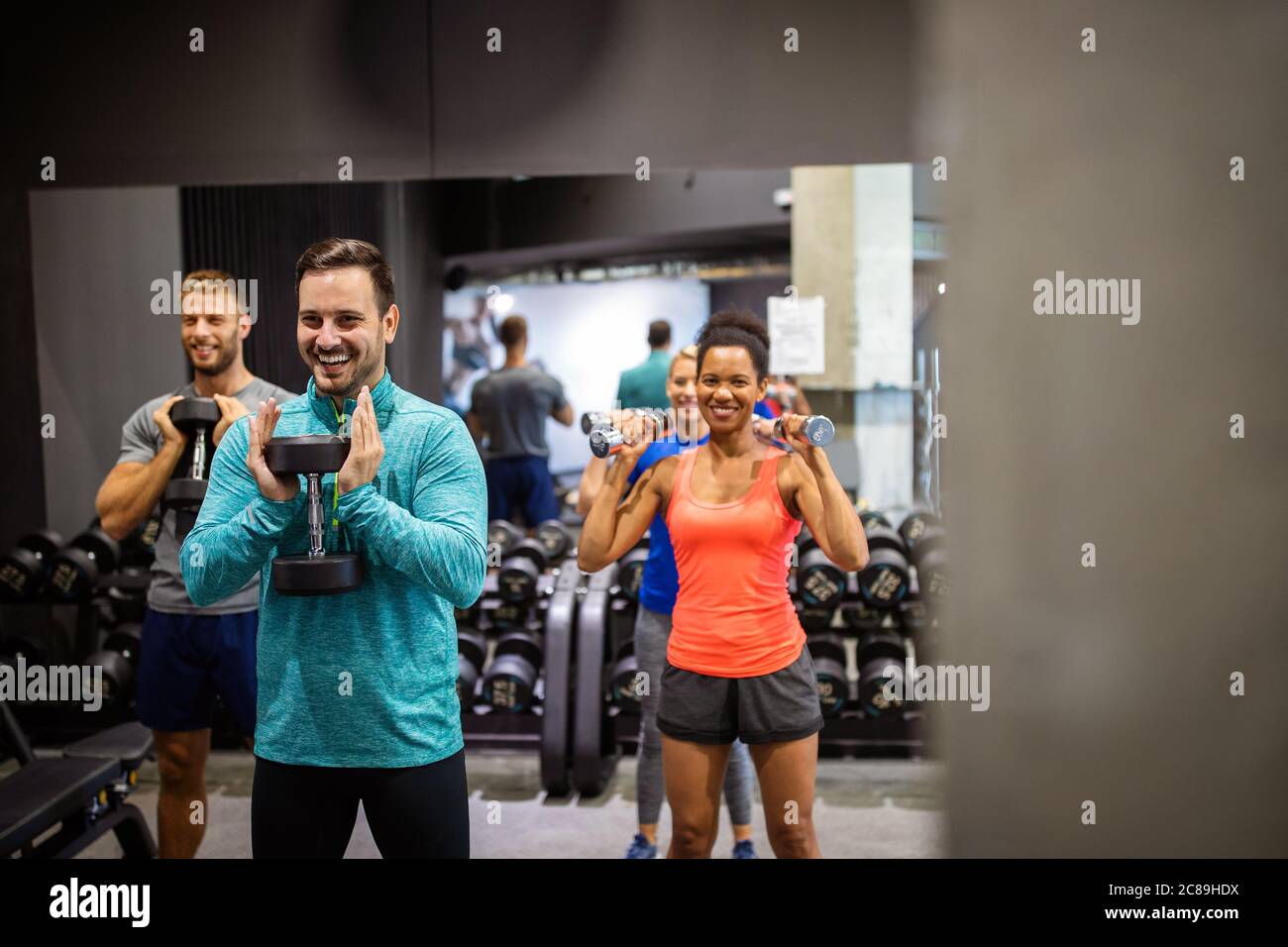 Forme physique, sport, entraînement, salle de sport, succès et concept de style de vie. Groupe d'amis heureux dans la salle de gym Banque D'Images