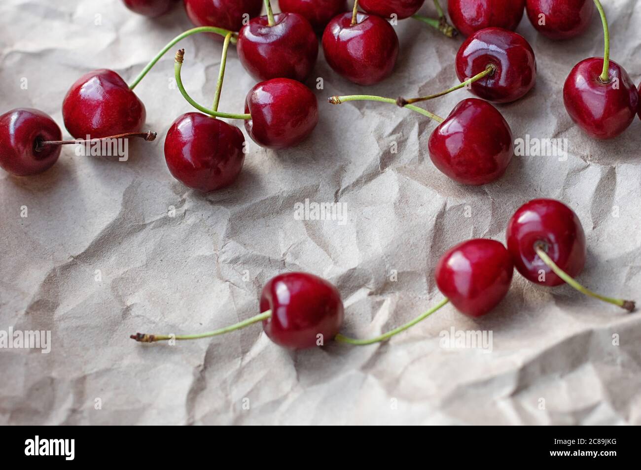 Baies de cerises mûres sur fond de papier artisanal. Mise au point sélective. Gros plan. Banque D'Images