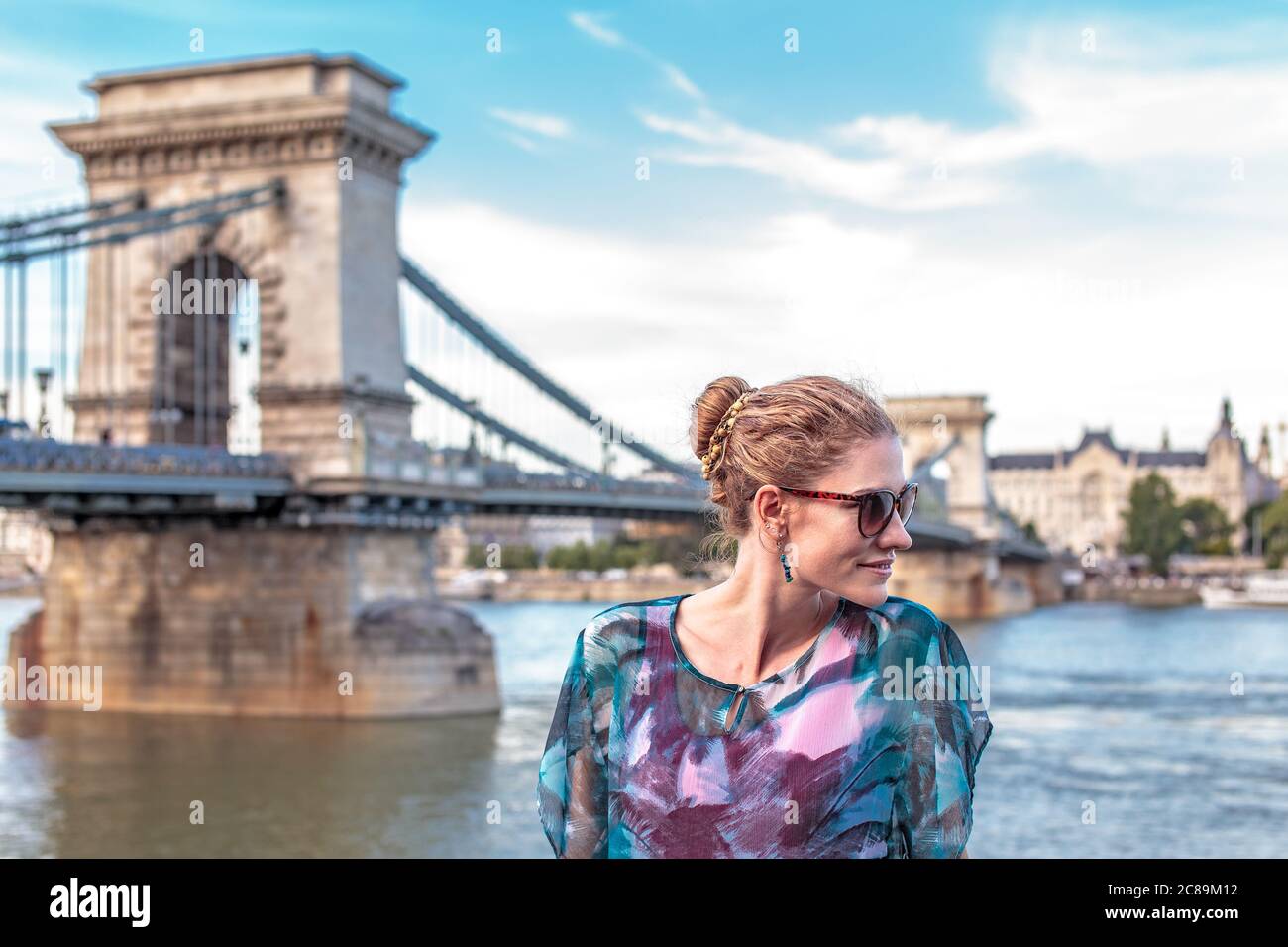 Bonne jeune femme à tête rouge qui regarde loin à Chain Bridge, Budapest, Hongrie Banque D'Images