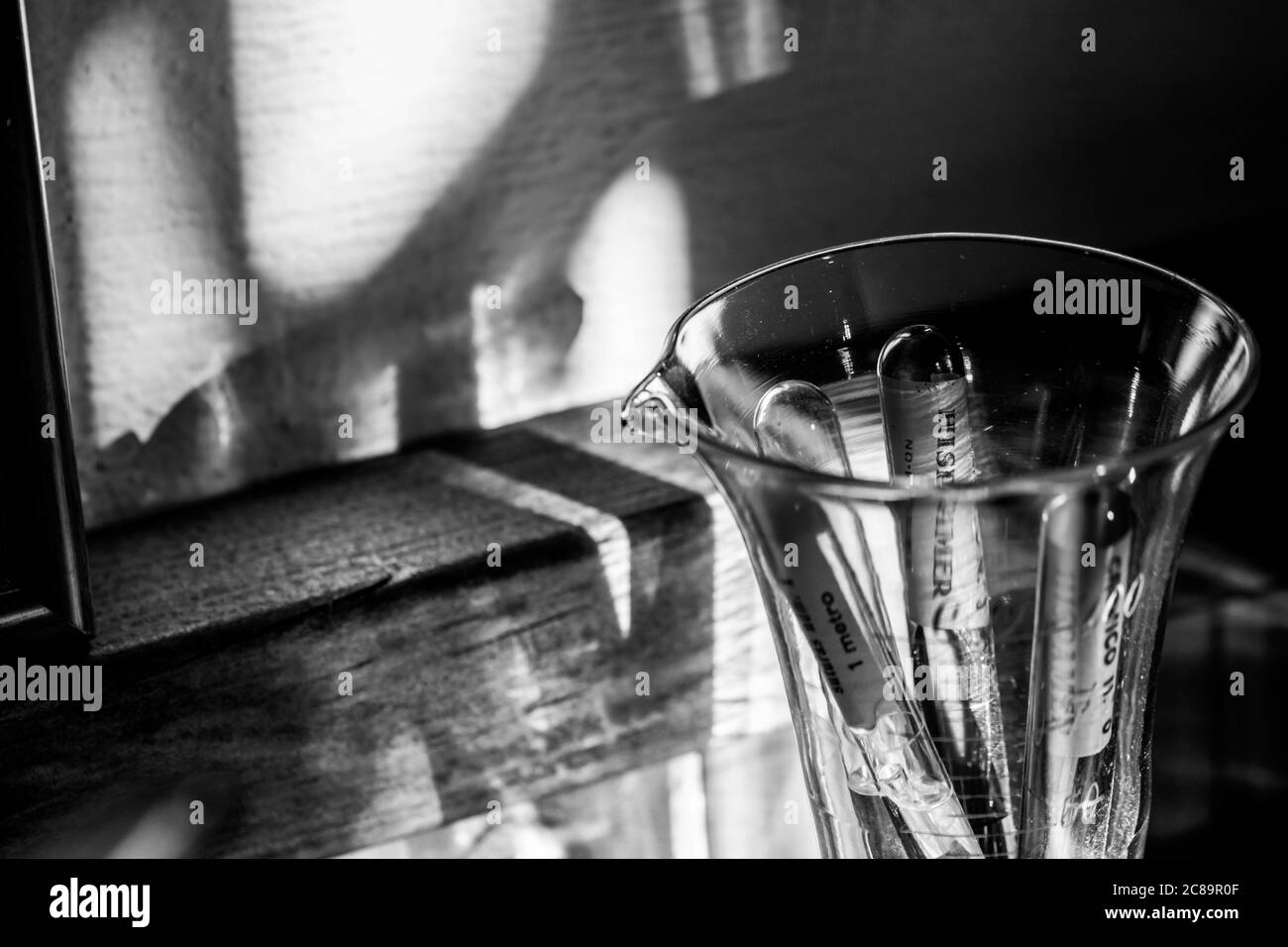 Ampoules en verre contenant des sutures en soie des années 1950 dans une tasse graduée. C'est une façon de contenir les fibres de soie sous une forme stérilisée Banque D'Images