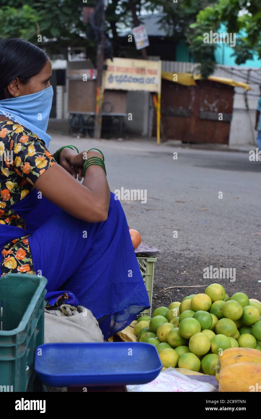 Hyderabad, Telangana, Inde. juillet-20-2020: Femme, négociant de fruits portait un masque dans son travail, des femmes vendant des fruits au côté de la route, petite entreprise Banque D'Images