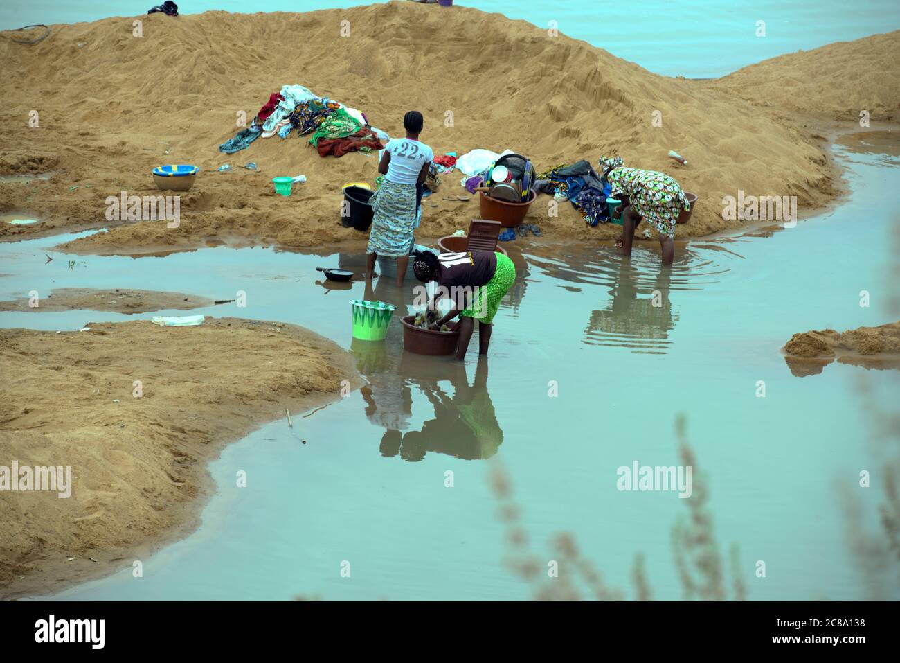 Les habitants de la région se mettent à se moder de leurs vêtements dans une rivière. Région de Mopti, Mali, Afrique de l'Ouest. Banque D'Images