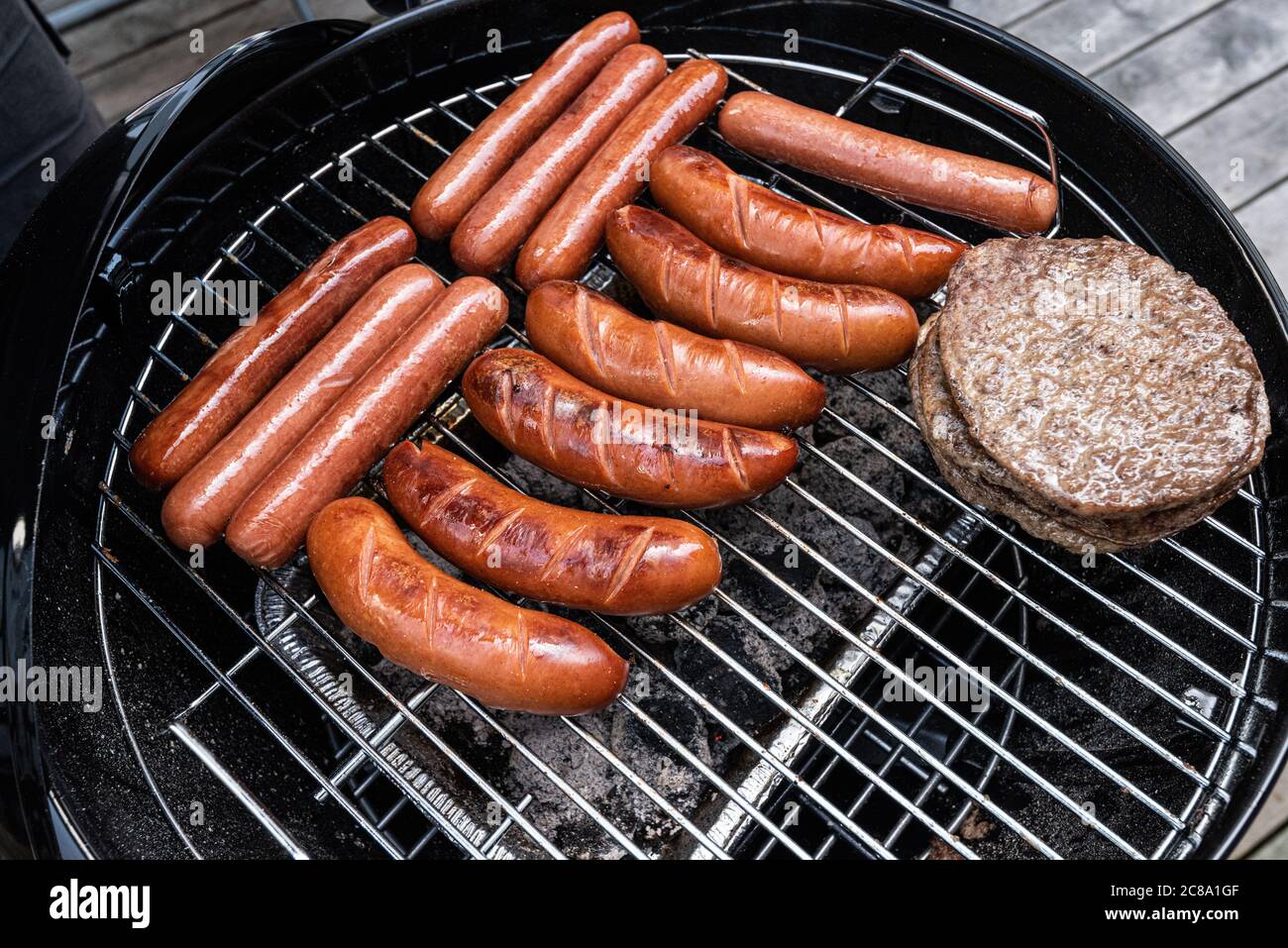 Hot dogs et hamburgers sur un barbecue au charbon. Banque D'Images
