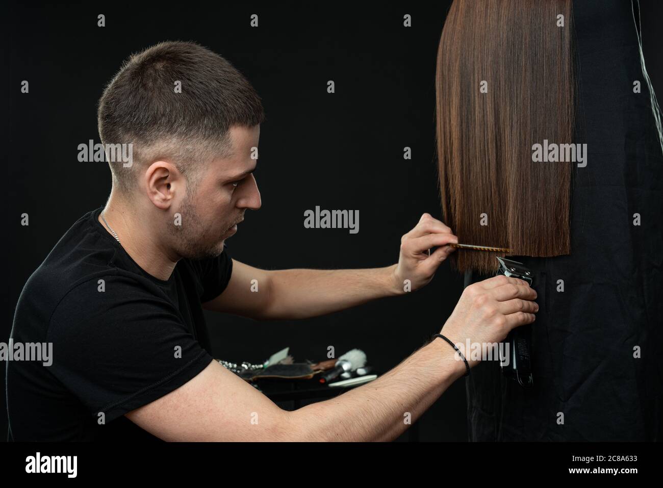 Un jeune homme confiant coiffeur se taille les cheveux à son client Banque D'Images