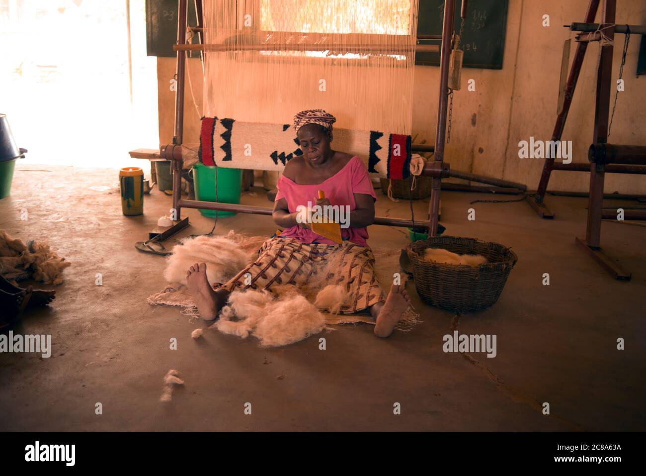 Une femme peigne la laine qui est utilisée pour faire des tapis. Sechou, Mali, Afrique de l'Ouest. Banque D'Images