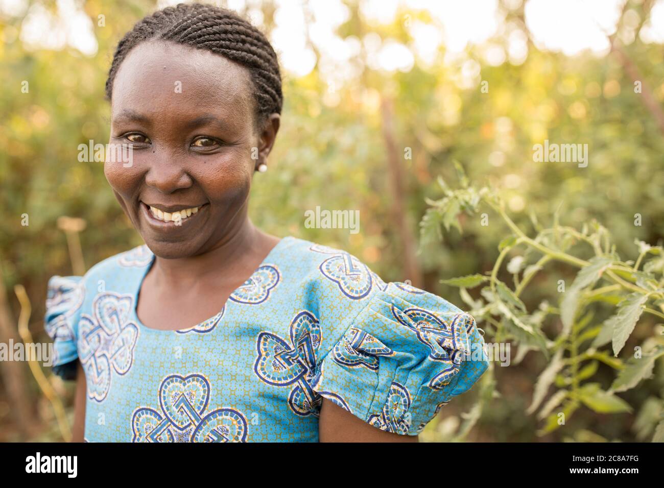 Portrait d'une femme africaine avec des tresses et une robe bleue - comté de Makueni, Kenya, Afrique de l'est. Banque D'Images