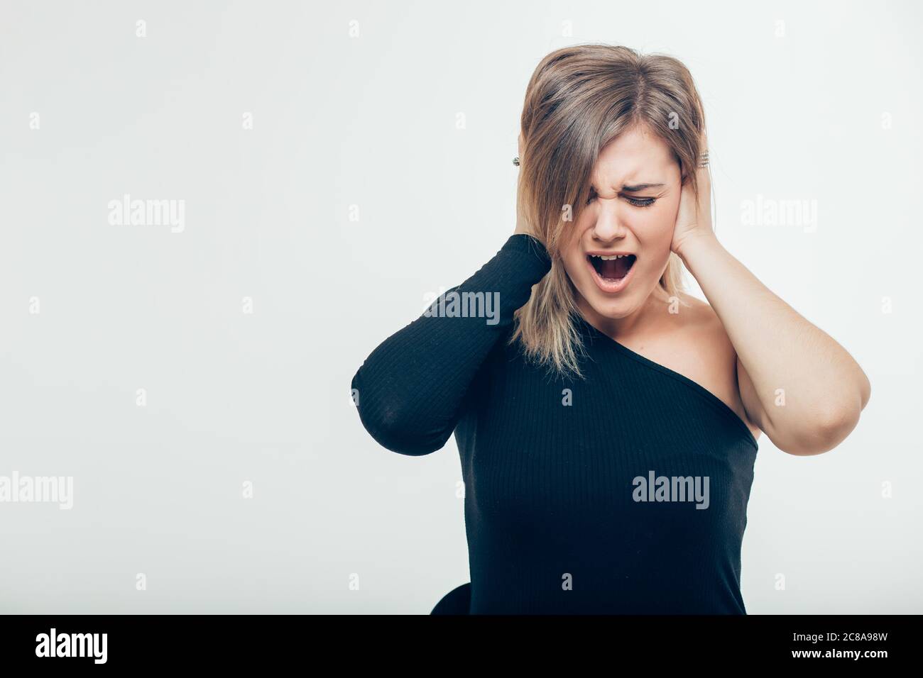 Belle jeune femme avec cheveux nœud ayant le mécontentement regarder se  boucher les oreilles étant énervé avec le bruit voulant silence et  l'atmosphère calme étant exha Photo Stock - Alamy