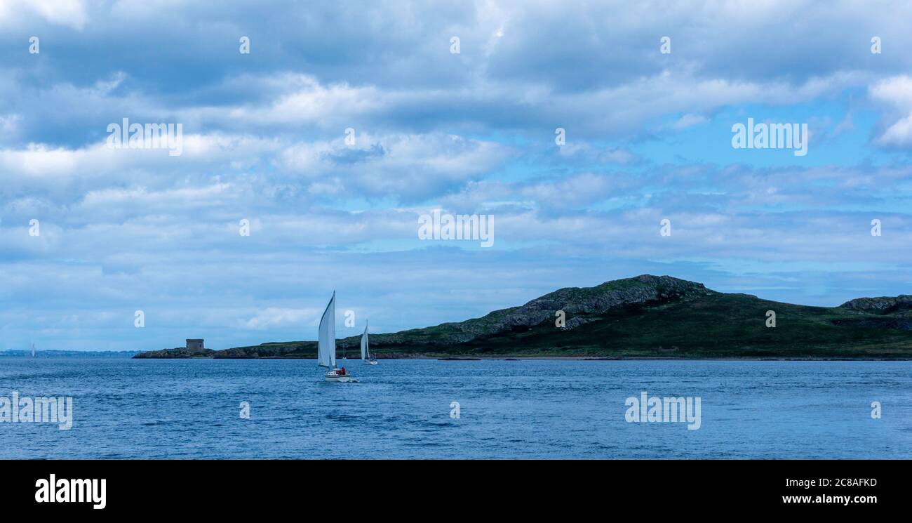 Yachts naviguant au large du port de Howth à Dublin avec l'île de Ireland's Eye en arrière-plan. Banque D'Images