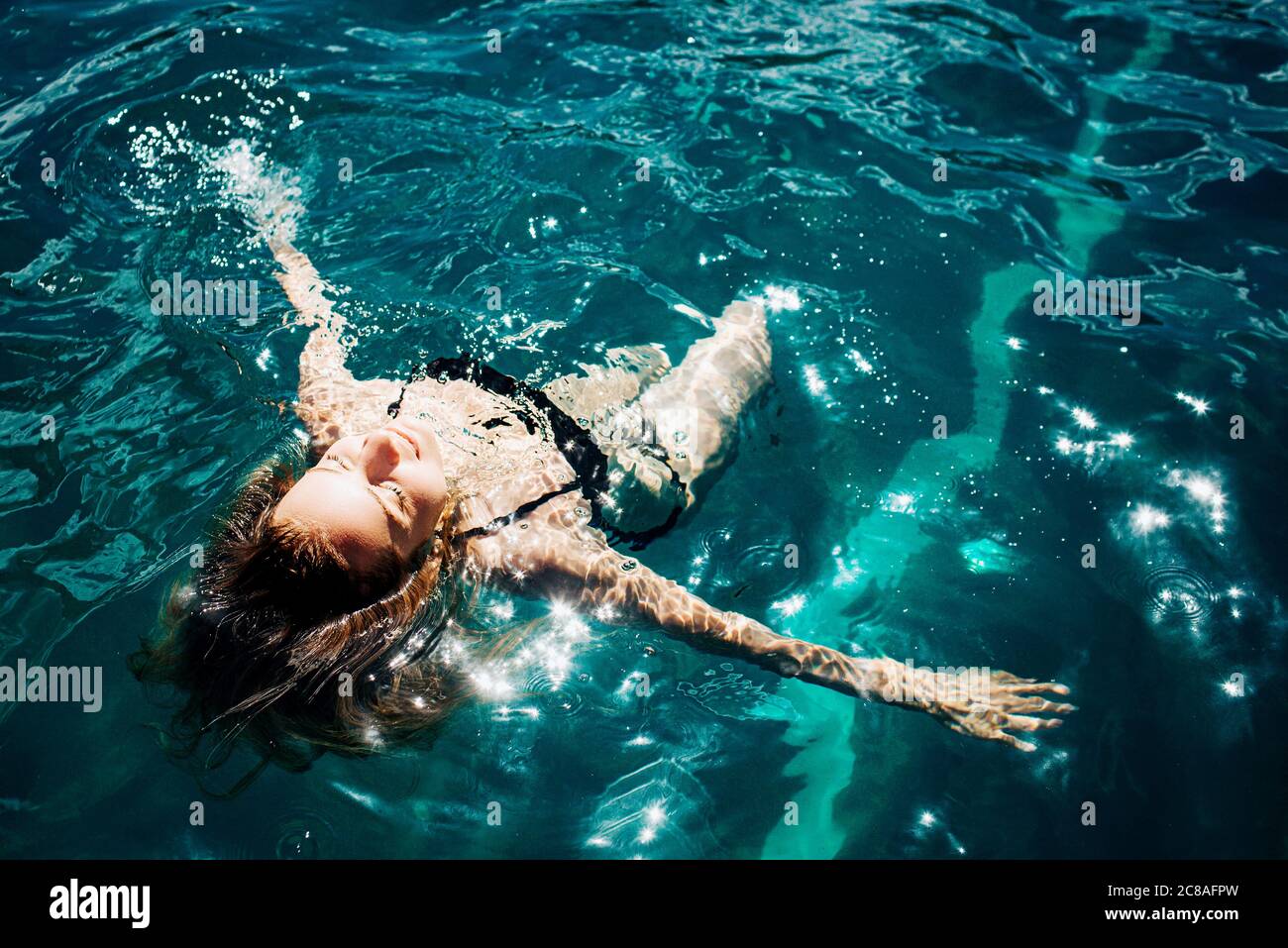 Jeune femme chaude se reposant seule. Fille nageant dans l'eau et appréciant. Reposez-vous et détendez-vous sous le soleil dehors. Resort spa place et joie à cause de la natation Banque D'Images