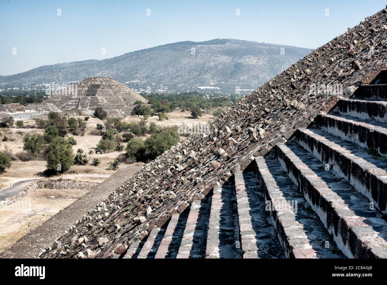 Pyramide de la Lune Teotihuacan Mexique // TEOTIHUACAN, Mexique — la Pyramide de la Lune vue du sommet de la Pyramide du Soleil sur l'ancien site archéologique mésoaméricain de Teotihuacan. L’avenue des morts, principale artère de cette ville précolombienne, s’étend entre ces deux grandes structures pyramidales. Teotihuacan a prospéré entre environ 100 et 650 EC et a été l'une des plus grandes villes du monde antique, avec une population estimée à plus de 100 000 à son apogée. La Pyramide de la Lune, mesurant environ 43 mètres (141 pieds) de haut, ancre l'extrémité nord du c Banque D'Images