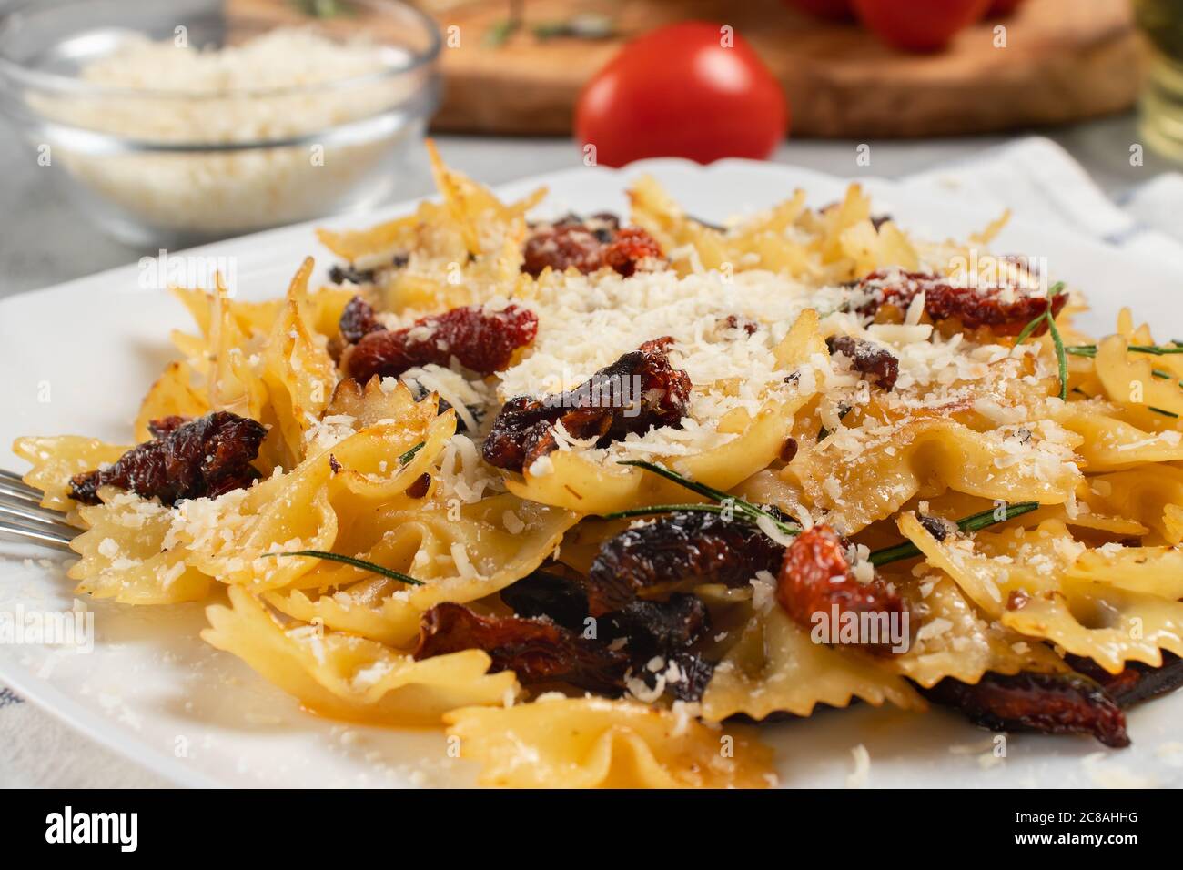 Pâtes avec tomates séchées et parmesan dans une assiette blanche sur la table. Plat italien, gros plan Banque D'Images