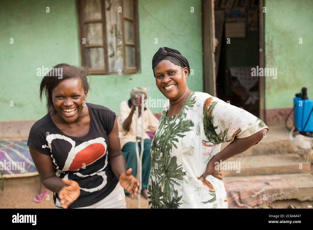 Rose Nabyonga (60) se tient avec sa petite-fille, Ketrah Nansikombi (21), devant leur maison dans le district de Kyotera, en Ouganda. LWR Ouganda JEUNES SEMENCES Proje Banque D'Images