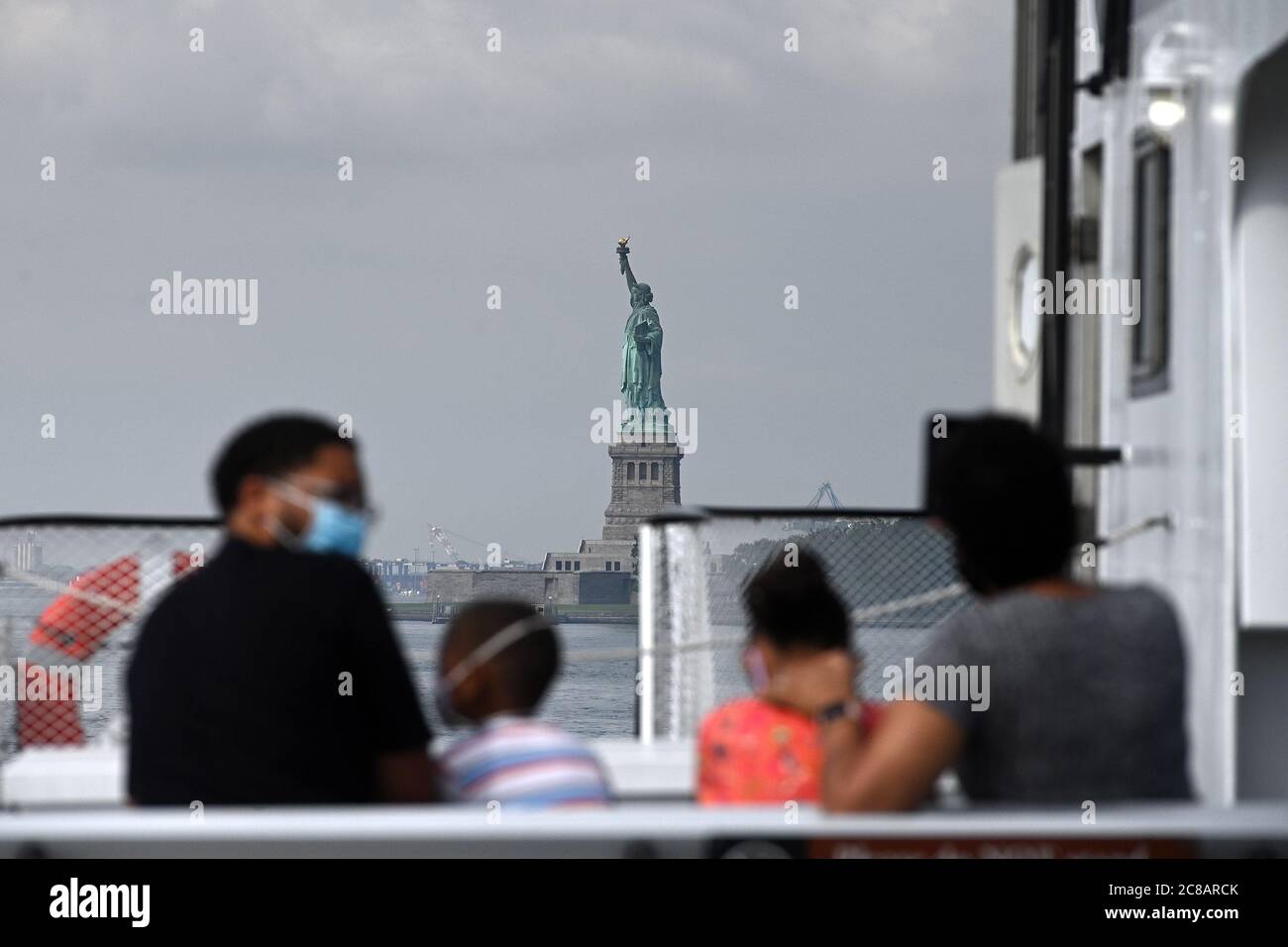 New York, États-Unis. 22 juillet 2020. La famille Fleming en visite au départ de Seattle, prenez un ferry pour Liberty Island maintenant accessible aux visiteurs dans le cadre de la réouverture de la ville de New York phase 4, mais l'accès à la Statue de la liberté elle-même, y compris la couronne et le piédestal, reste fermé en raison des restrictions de la COVID-19, New York, NY, 22 juillet 2020. Depuis son ouverture lundi, les foules habituelles de dizaines de milliers de personnes ont été absentes, au lieu de cela, un flux lent de quelques centaines de touristes seulement ont été comptés visitant la « Dame liberté ». (Anthony Behar/Sipa USA) crédit: SIPA USA/Alay Live News Banque D'Images