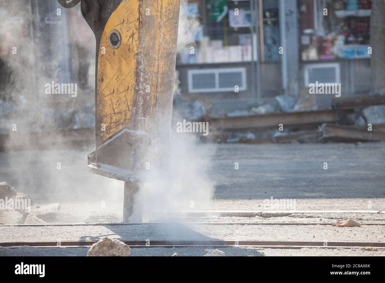 Jackhammer monté sur un véhicule de rénovation, avec un semoir pneumatique perforant l'asphalte d'une route urbaine en cours de rénovation sur une rue de construction s. Banque D'Images