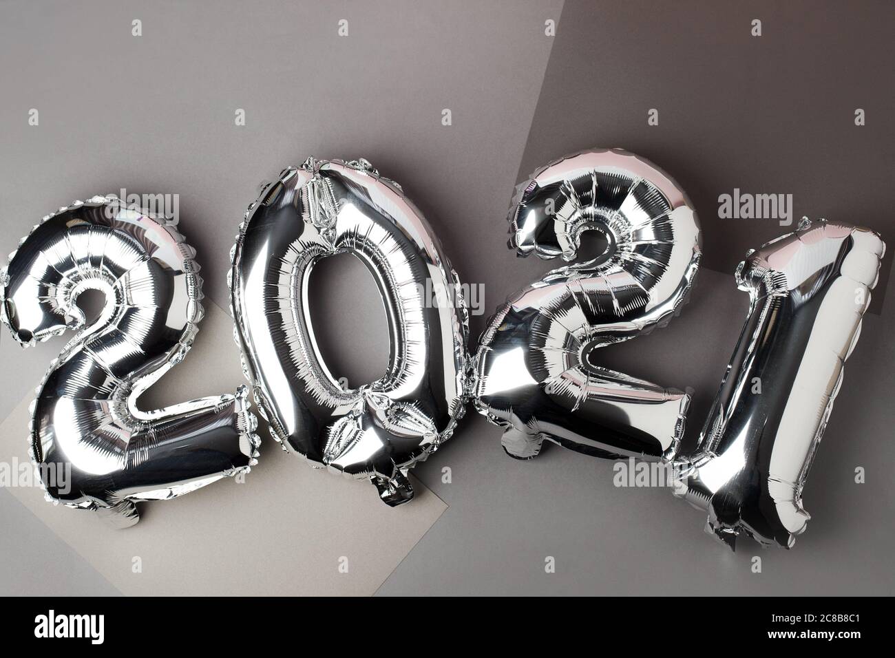 Noël nouvel an 2021 numéros argent ballons d'air sur gris. Célébration, arrière-plan créatif saisonnier des fêtes, pose à plat, bannière pour le site, décoration de fête Banque D'Images