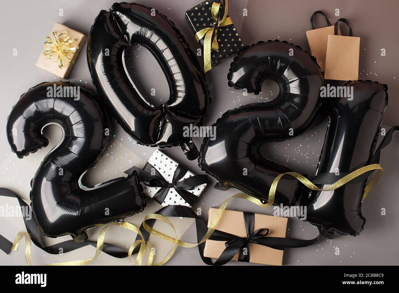 Noël nouvel an 2021 numéros ballons GAIR noir élégant et boîtes cadeau sur gris. Célébration, arrière-plan créatif des fêtes de saison, bannière Banque D'Images